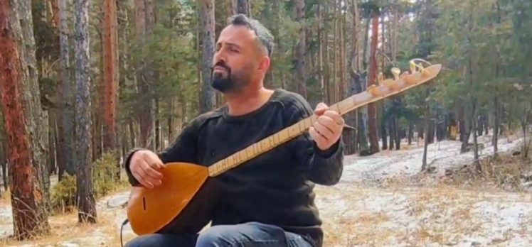 Erzurum’da Müzik Öğretmeni Mehmet Baki, doğada kar altında saz çalarak türküler söylüyor.